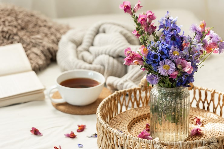Fresh wildflowers in a vase on a breakfast table with morning sunlight, creating a romanticized morning routine.